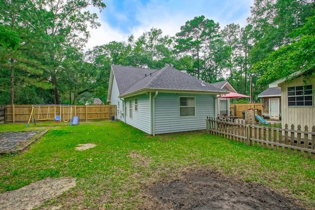 70380 K St, Covington, LA 70433 - rear view of property featuring roof with shingles, a fenced backyard, and view of wooded area