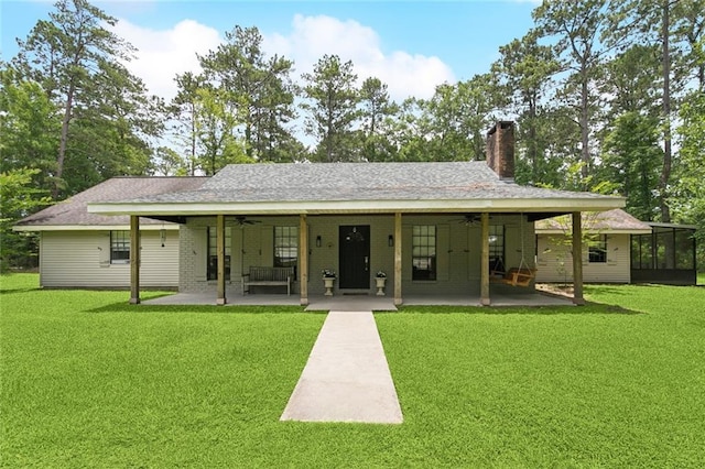 20226 Chandler Dr, Covington, LA 70435 - rear view of house with a ceiling fan, a patio, a lawn, and a chimney