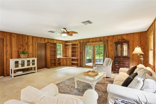 20226 Chandler Dr, Covington, LA 70435 - living area featuring wood walls, light carpet, ceiling fan, built in features, and french doors
