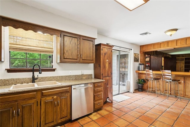 20226 Chandler Dr, Covington, LA 70435 - kitchen featuring stainless steel dishwasher, light tile patterned floors, and light countertops