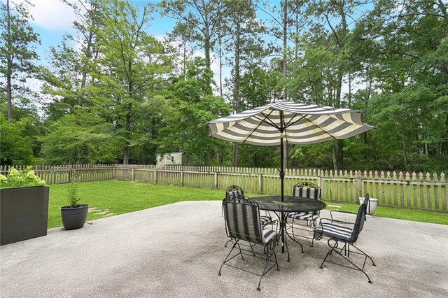 20226 Chandler Dr, Covington, LA 70435 - fenced backyard featuring a patio area, outdoor dining area, and view of wooded area