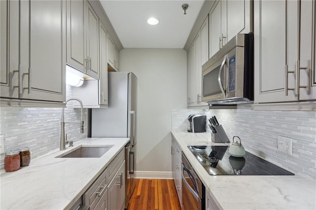 214 Chartres St Unit 3, New Orleans, LA 70130 - kitchen featuring stainless steel microwave, oven, gray cabinets, black electric stovetop, and tasteful backsplash