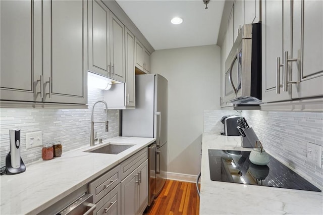 214 Chartres St Unit 3, New Orleans, LA 70130 - kitchen with gray cabinetry, appliances with stainless steel finishes, tasteful backsplash, light stone countertops, and dark wood finished floors