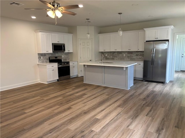 2035 Huey P Lng Ave, Gretna, LA 70053 - kitchen with stainless steel appliances, a ceiling fan, light countertops, white cabinets, and recessed lighting