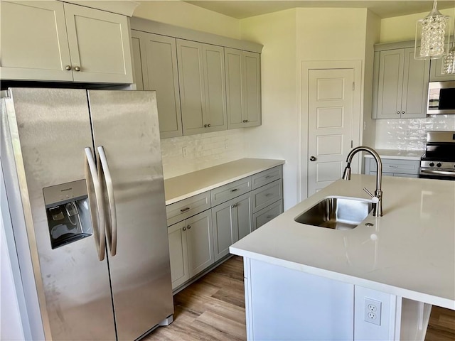 2444 Huey P Long Ave, Gretna, LA 70053 - kitchen featuring stainless steel appliances, gray cabinets, backsplash, light countertops, and light wood finished floors