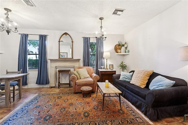 515 Sidney St, Metairie, LA 70005 - living room featuring a chandelier, a textured ceiling, a fireplace, and tile patterned flooring