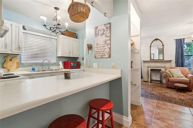 515 Sidney St, Metairie, LA 70005 - kitchen with a kitchen bar, light countertops, white cabinetry, and light tile patterned flooring