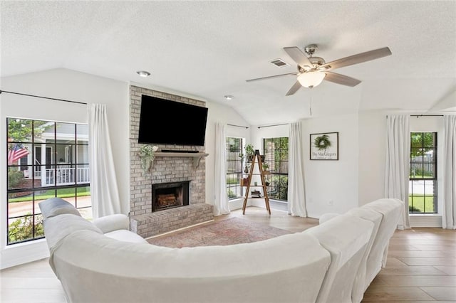 104 Inverrary Ct, Slidell, LA 70460 - living room with lofted ceiling, a textured ceiling, ceiling fan, a fireplace, and wood finished floors