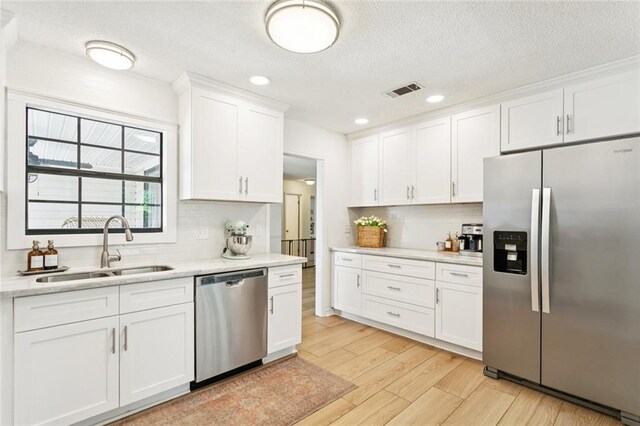 104 Inverrary Ct, Slidell, LA 70460 - kitchen with stainless steel appliances, light countertops, tasteful backsplash, white cabinets, and light wood-style floors
