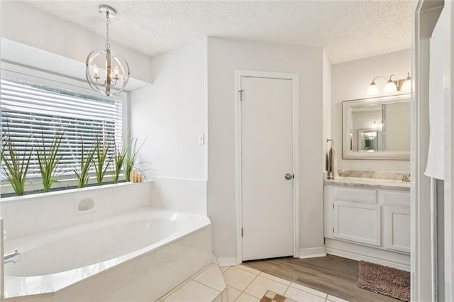 104 Inverrary Ct, Slidell, LA 70460 - full bath with vanity, a bath, a textured ceiling, a chandelier, and tile patterned flooring