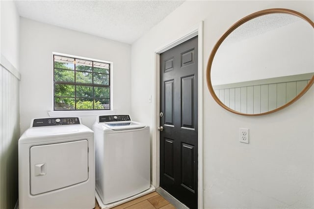 104 Inverrary Ct, Slidell, LA 70460 - laundry room with washing machine and clothes dryer, light wood finished floors, and a textured ceiling