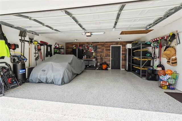 104 Inverrary Ct, Slidell, LA 70460 - garage featuring a garage door opener and wooden walls