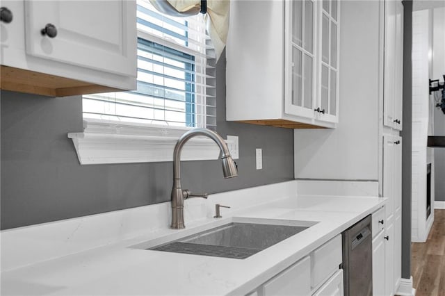 506 Ellington Ave, Luling, LA 70070 - kitchen featuring stainless steel dishwasher, white cabinetry, glass insert cabinets, light stone counters, and wood finished floors