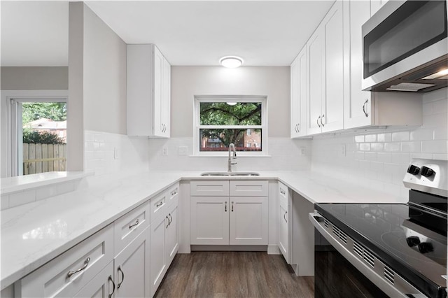 5720 Count Ln, New Orleans, LA 70126 - kitchen featuring stainless steel appliances, light stone counters, white cabinets, dark wood-type flooring, and decorative backsplash