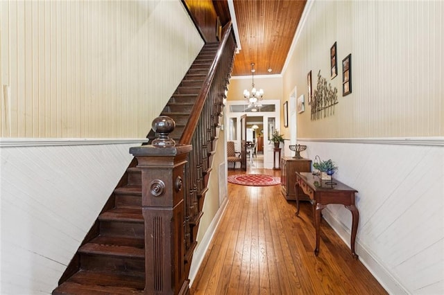 39267 Z Oaks Ln, Ponchatoula, LA 70454 - staircase featuring hardwood / wood-style floors, a chandelier, wainscoting, wooden walls, and ornamental molding