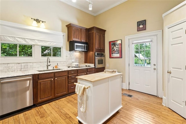 39267 Z Oaks Ln, Ponchatoula, LA 70454 - kitchen featuring stainless steel appliances, ornamental molding, tasteful backsplash, light wood-style floors, and light stone counters