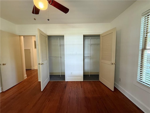 312 W 20th Ave, Covington, LA 70433 - unfurnished bedroom featuring multiple closets, dark wood finished floors, ceiling fan, and multiple windows
