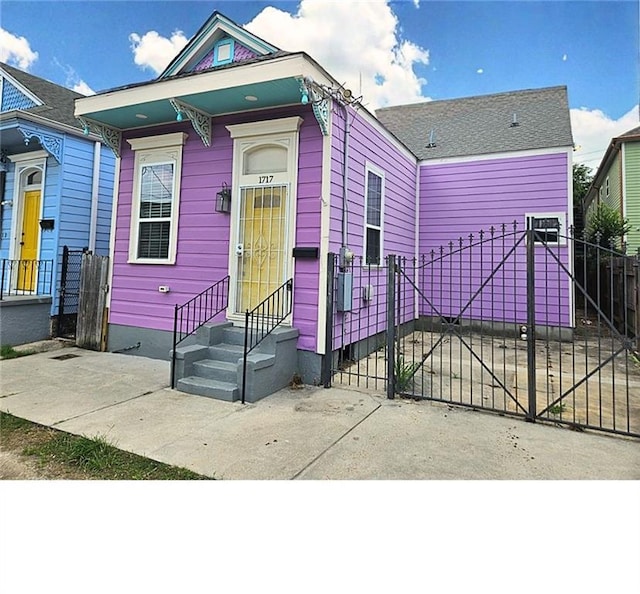 1717 Governor Nicholls St, New Orleans, LA 70116 - shotgun-style home with a fenced front yard, a gate, and entry steps