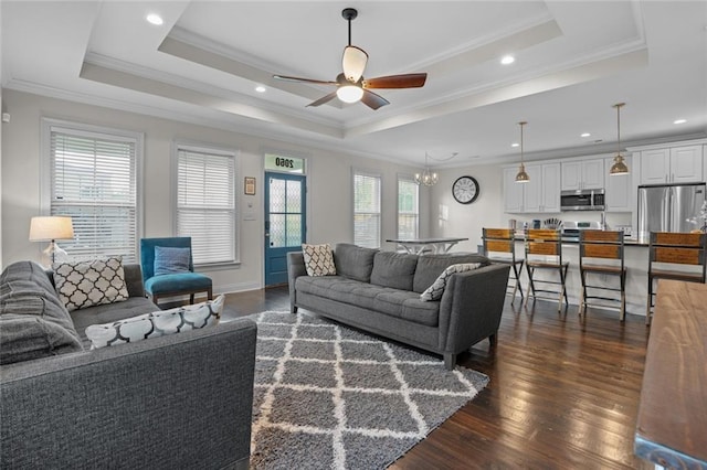 2060 Saint Denis St, New Orleans, LA 70122 - living room featuring a ceiling fan, dark wood-style flooring, a raised ceiling, crown molding, and a chandelier