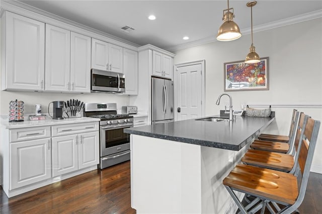 2060 Saint Denis St, New Orleans, LA 70122 - kitchen with appliances with stainless steel finishes, ornamental molding, dark wood-type flooring, white cabinets, and pendant lighting