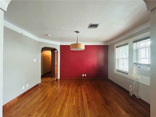 402 Orion Ave, Metairie, LA 70005 - spare room featuring arched walkways, wood finished floors, and ornamental molding