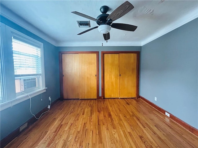 402 Orion Ave, Metairie, LA 70005 - unfurnished bedroom with cooling unit, light wood-style floors, ornamental molding, ceiling fan, and multiple closets