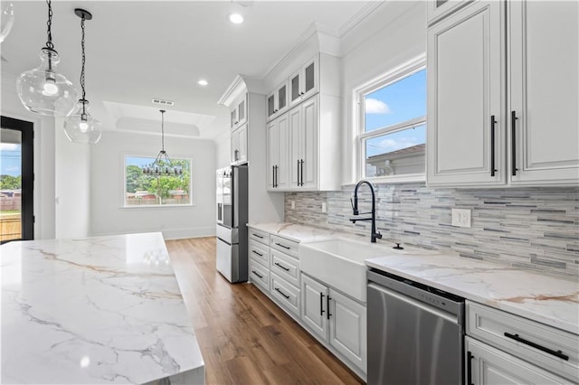 7717 Richard St, Metairie, LA 70003 - kitchen featuring appliances with stainless steel finishes, a tray ceiling, dark wood-style floors, tasteful backsplash, and plenty of natural light