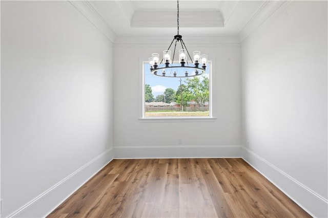 7717 Richard St, Metairie, LA 70003 - unfurnished dining area with a chandelier, ornamental molding, a raised ceiling, and wood finished floors