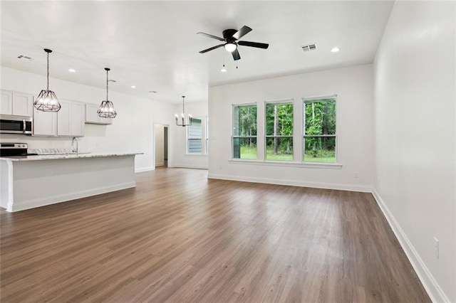 69206 4th Ave, Covington, LA 70433 - unfurnished living room featuring recessed lighting, wood finished floors, ceiling fan, and a chandelier