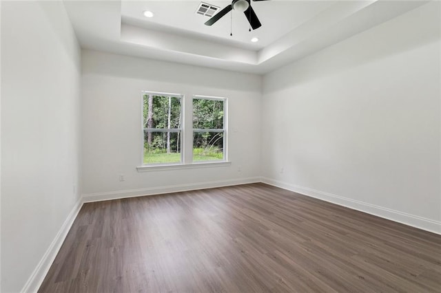 69206 4th Ave, Covington, LA 70433 - spare room featuring dark wood-style floors, a tray ceiling, a ceiling fan, and recessed lighting