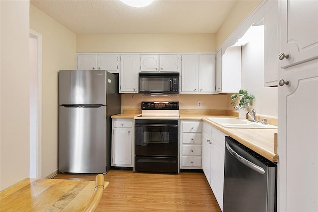 2700 Whitney Pl Unit 826, Metairie, LA 70002 - kitchen featuring appliances with stainless steel finishes, white cabinets, and light wood-type flooring