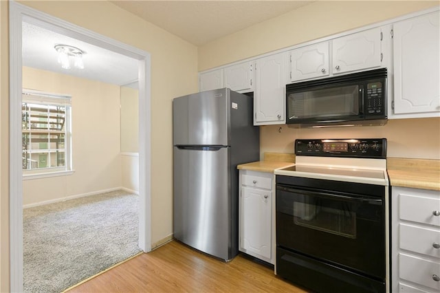 2700 Whitney Pl Unit 826, Metairie, LA 70002 - kitchen with black microwave, range with electric cooktop, freestanding refrigerator, light countertops, and white cabinetry