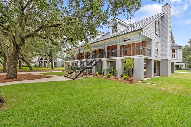 2801 Lakeshore Dr, Mandeville, LA 70448 - rear view of property with a lawn, stairs, a metal roof, a chimney, and a ceiling fan