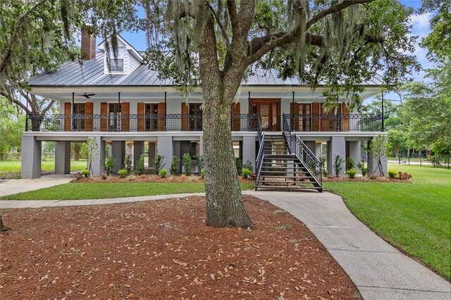 2801 Lakeshore Dr, Mandeville, LA 70448 - view of front of property with stairs, covered porch, a front yard, a chimney, and french doors