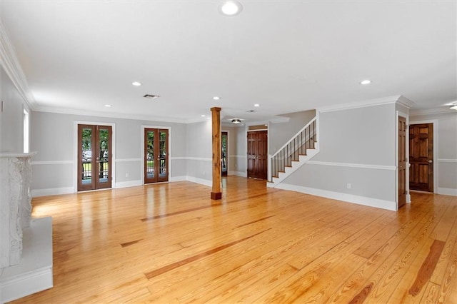 2801 Lakeshore Dr, Mandeville, LA 70448 - unfurnished living room featuring crown molding, recessed lighting, ornate columns, stairs, and light wood-type flooring