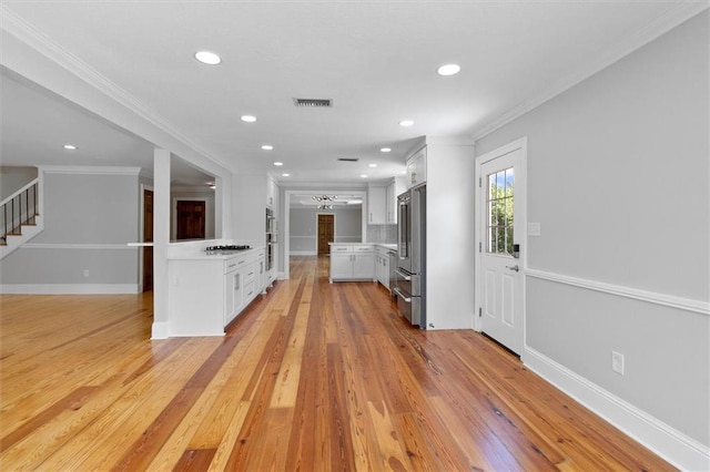 2801 Lakeshore Dr, Mandeville, LA 70448 - kitchen with light countertops, white cabinets, light wood-style floors, high quality fridge, and recessed lighting