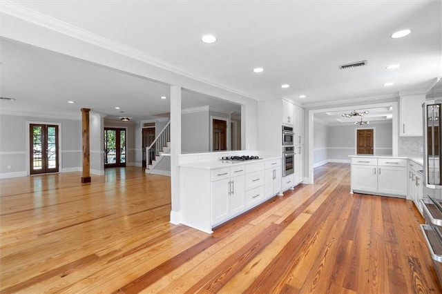 2801 Lakeshore Dr, Mandeville, LA 70448 - kitchen featuring ornamental molding, french doors, gas stovetop, light countertops, and open floor plan