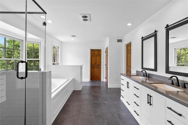 2801 Lakeshore Dr, Mandeville, LA 70448 - full bathroom with double vanity, a garden tub, tile patterned floors, a stall shower, and recessed lighting