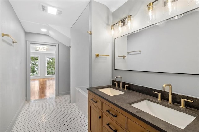2801 Lakeshore Dr, Mandeville, LA 70448 - full bathroom with a tub to relax in, double vanity, tile patterned floors, and vaulted ceiling