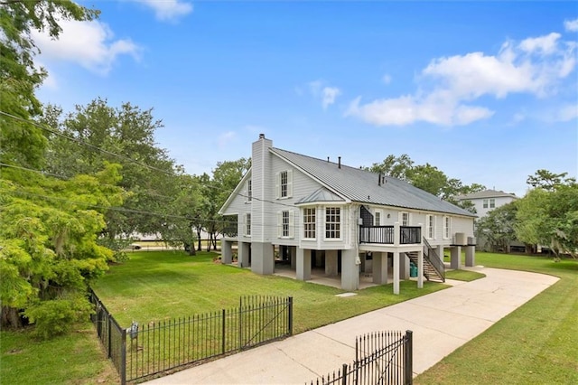 2801 Lakeshore Dr, Mandeville, LA 70448 - view of side of property featuring a fenced front yard, a deck, stairway, driveway, and a chimney