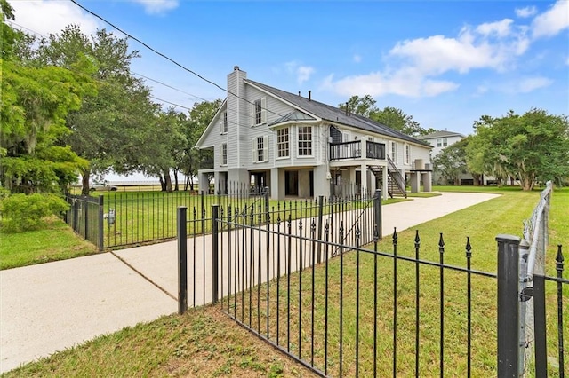 2801 Lakeshore Dr, Mandeville, LA 70448 - view of front of property featuring a fenced front yard, a chimney, concrete driveway, stairway, and a deck