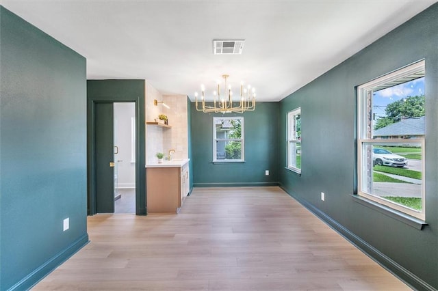 145 Macque Dr, Harahan, LA 70123 - unfurnished dining area with a chandelier and light wood-style flooring