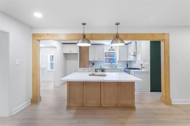 145 Macque Dr, Harahan, LA 70123 - kitchen with high end stainless steel range, custom range hood, light wood-style floors, backsplash, and recessed lighting