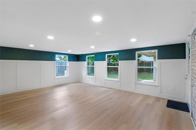 145 Macque Dr, Harahan, LA 70123 - unfurnished living room with a decorative wall, light wood-style floors, a wainscoted wall, and recessed lighting