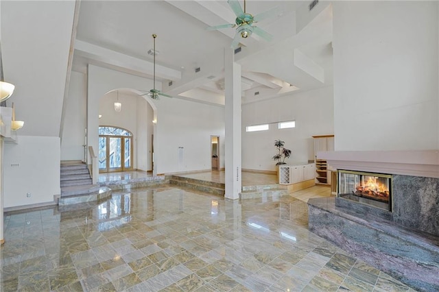 3128 Palm Vista Dr, Metairie, LA 70003 - unfurnished living room with a ceiling fan, healthy amount of natural light, a multi sided fireplace, a high ceiling, and beamed ceiling