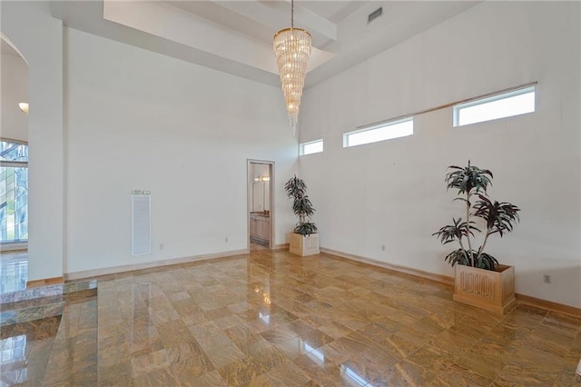 3128 Palm Vista Dr, Metairie, LA 70003 - spare room with a high ceiling, a chandelier, arched walkways, and marble tiled flooring