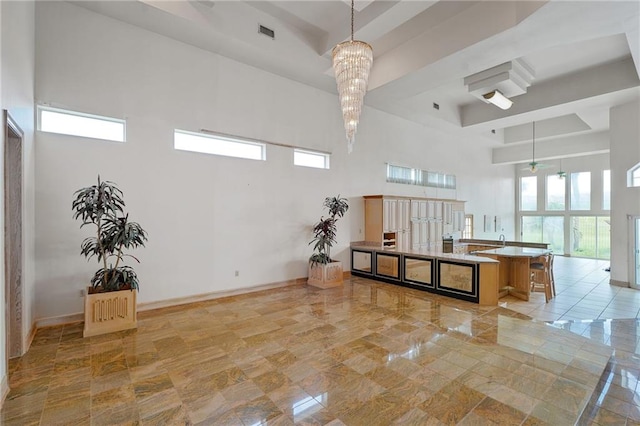 3128 Palm Vista Dr, Metairie, LA 70003 - kitchen featuring a high ceiling, hanging light fixtures, a center island with sink, and beam ceiling
