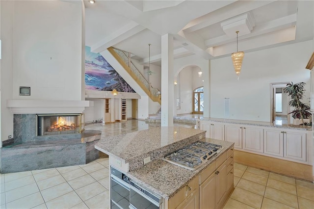 3128 Palm Vista Dr, Metairie, LA 70003 - kitchen with open floor plan, stainless steel gas stovetop, light tile patterned floors, beamed ceiling, and light stone counters