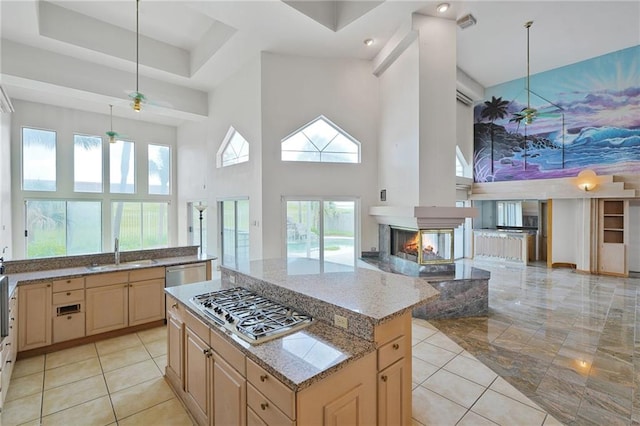 3128 Palm Vista Dr, Metairie, LA 70003 - kitchen featuring a towering ceiling, appliances with stainless steel finishes, light brown cabinetry, open floor plan, and light stone countertops
