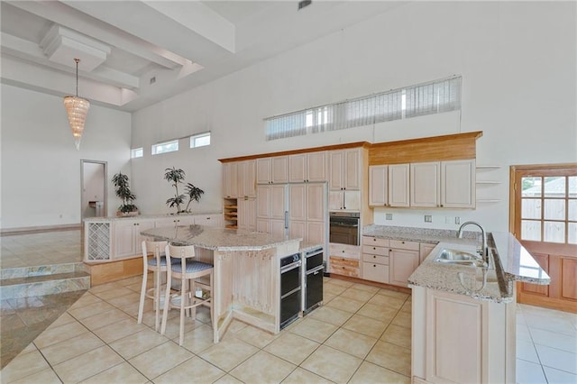 3128 Palm Vista Dr, Metairie, LA 70003 - kitchen featuring a high ceiling, open shelves, a peninsula, black oven, and a breakfast bar